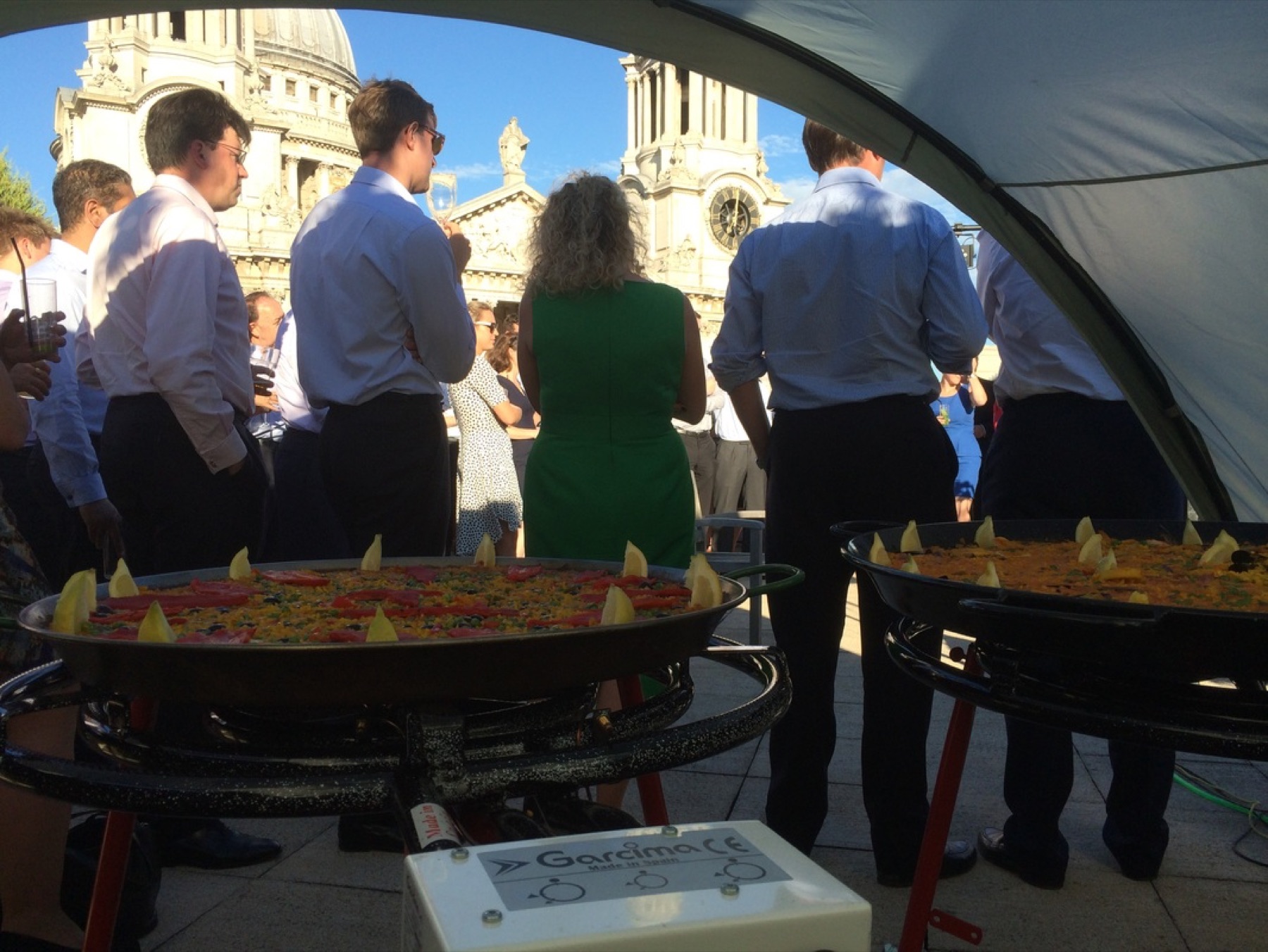 Wedding guests enjoying paella cooked outdoors